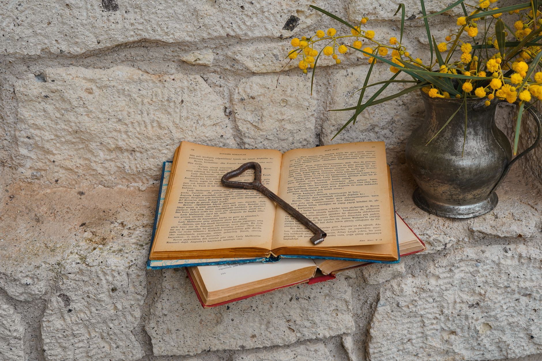 open book with antique key and mimosa flowers